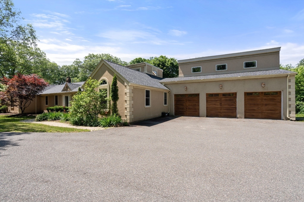 242 Boston Road Sutton, MA 01590 - Photo 4 of 39 a front view of a house with a yard and garage
