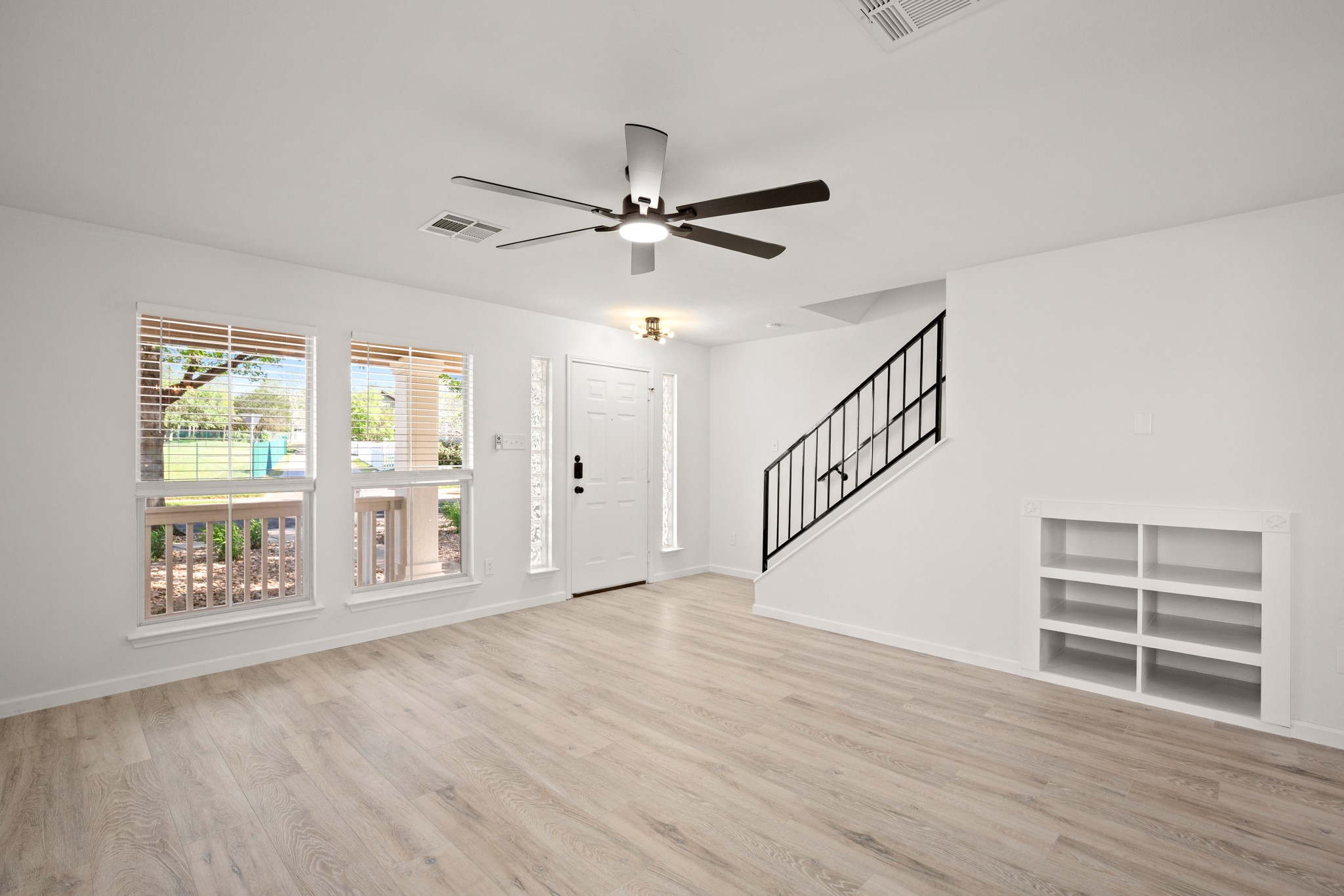 360 Sampson Kyle, TX 78640 - Photo 9 of 36 Open living space featuring light wood-finish flooring, a contemporary ceiling fan, and multiple windows with blinds