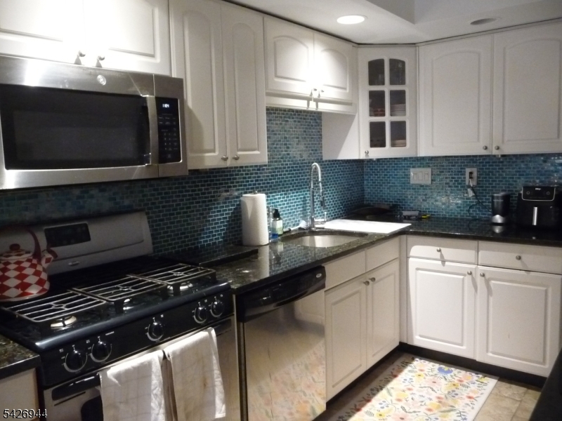 29 Up Mountain Avenue, Unit 2 Montclair, NJ 07042 - Photo 9 of 15 a kitchen with stainless steel appliances a stove a microwave a sink and cabinets