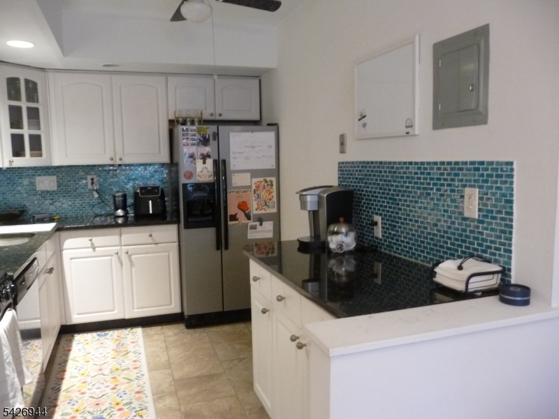 29 Up Mountain Avenue, Unit 2 Montclair, NJ 07042 - Photo 10 of 15 a kitchen with a sink dishwasher a refrigerator and white cabinets with wooden floor