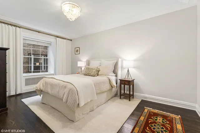 a bedroom with a bed and a window with a chair