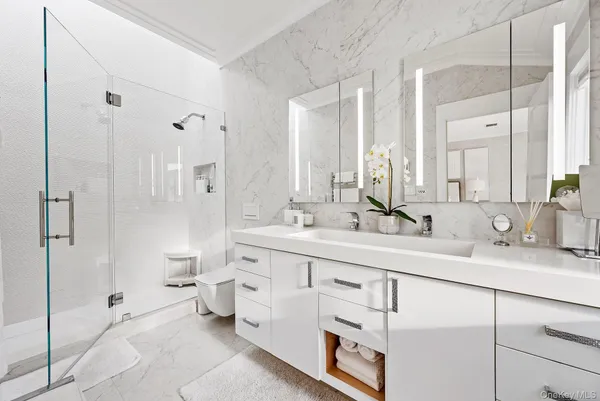 a bathroom with a double vanity sink mirror and toilet