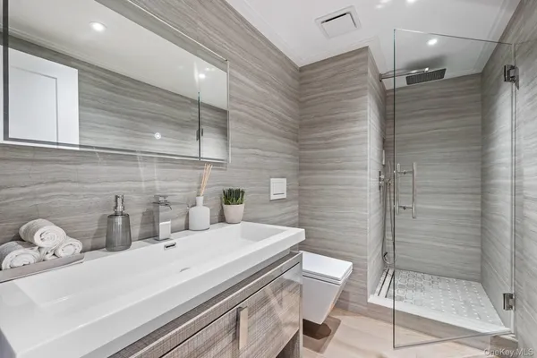 a bathroom with a sink a toilet and shower