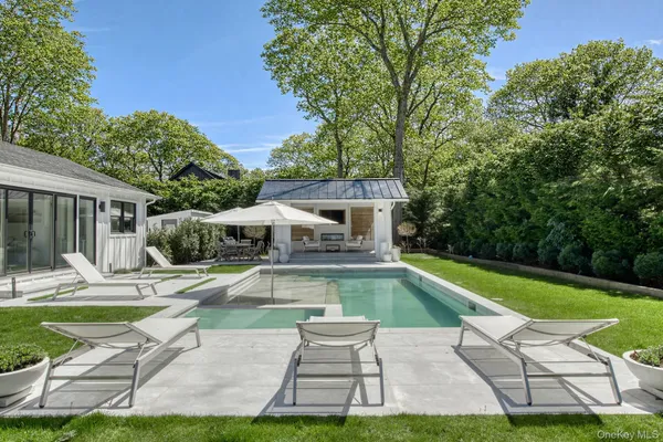 a view of a house with swimming pool and sitting area