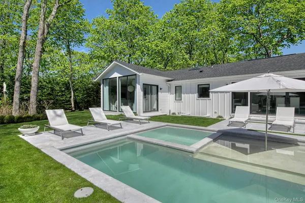 a view of a house with backyard patio and swimming pool