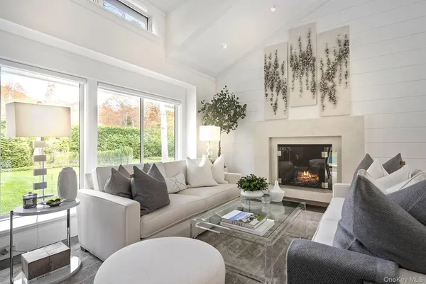a living room with furniture fireplace and a large window