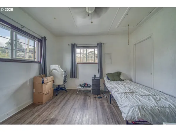 a bedroom with a bed and wooden floor
