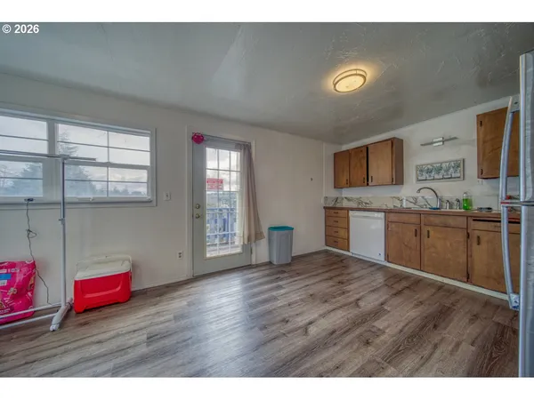 a view of kitchen with wooden floor and electronic appliances