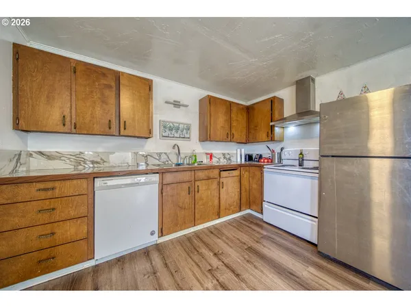a kitchen with granite countertop wooden cabinets and white appliances