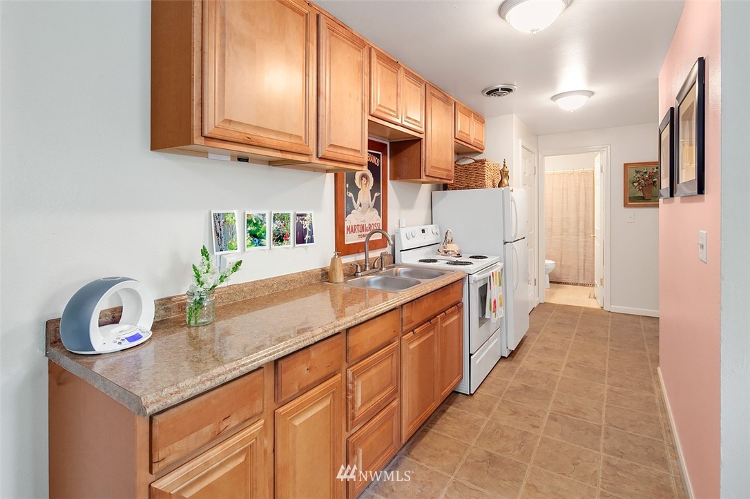 9802 Northeast 188th Street Bothell, WA 98011 - Photo 8 of 18 a kitchen with granite countertop a sink a stove and cabinets