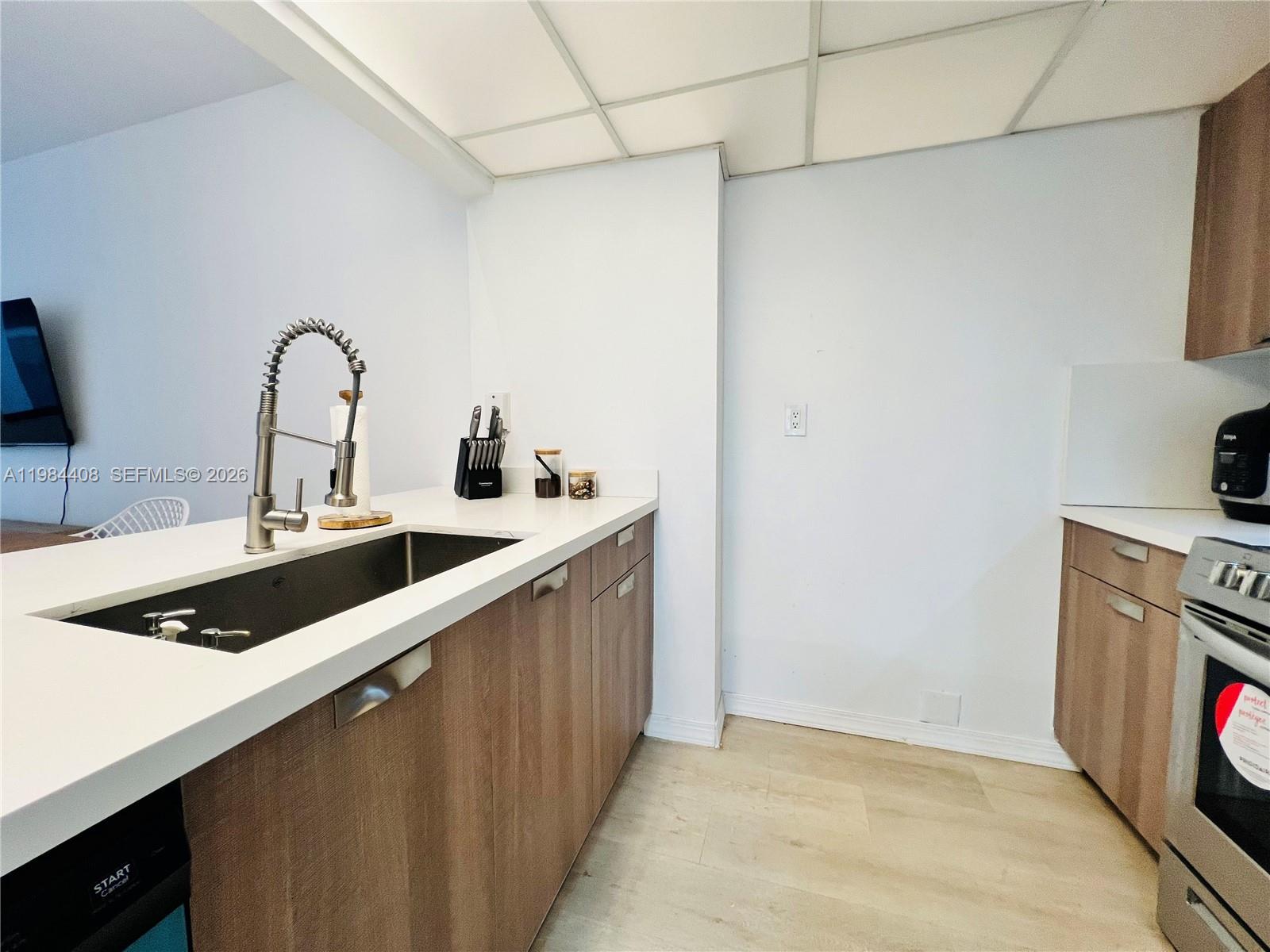 540 Brickell Key Drive, Unit 202 Miami, FL 33131 - Photo 12 of 31 a kitchen with a sink and a stove top oven