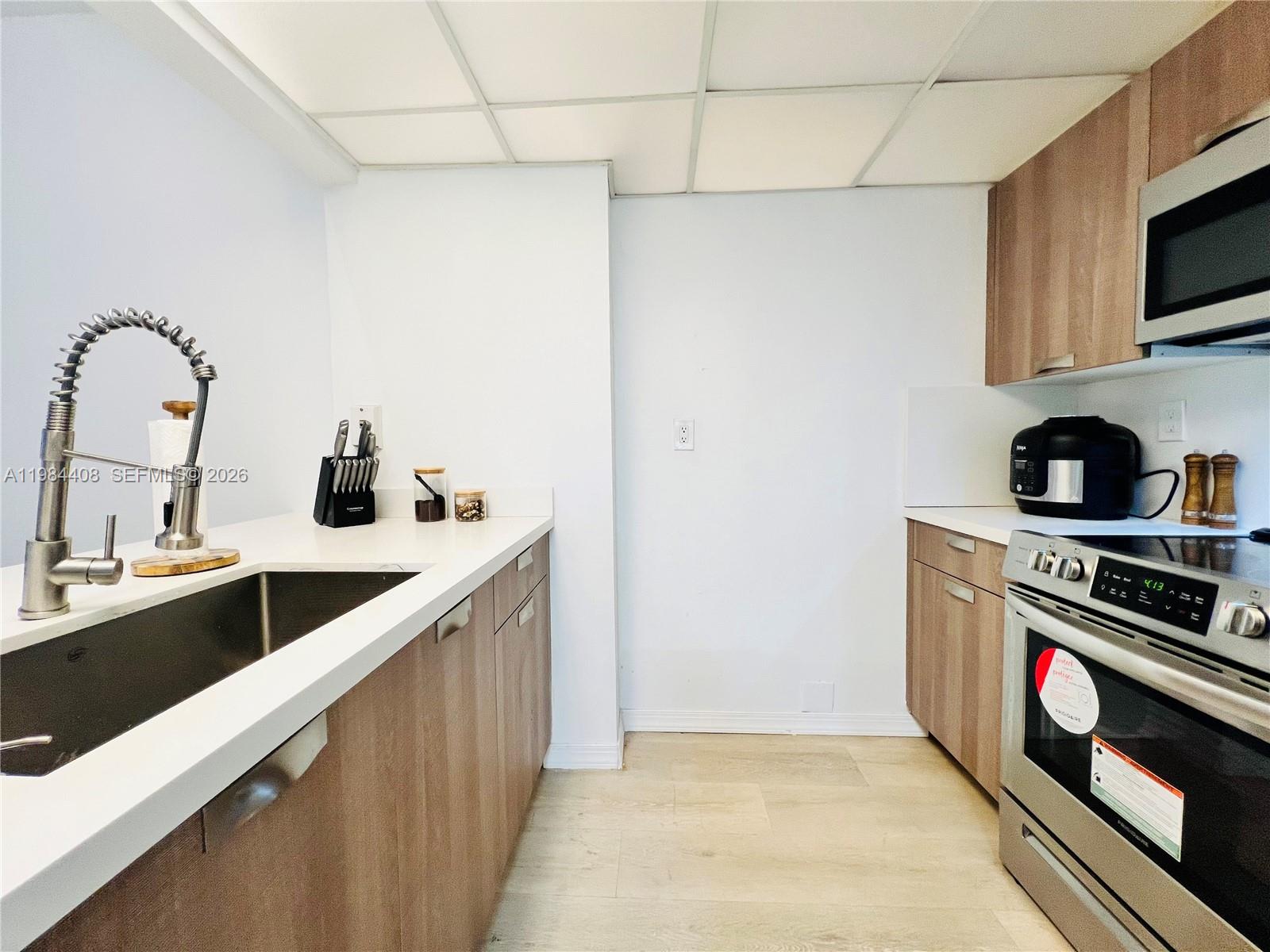 540 Brickell Key Drive, Unit 202 Miami, FL 33131 - Photo 13 of 31 a kitchen with stainless steel appliances a sink stove and cabinets