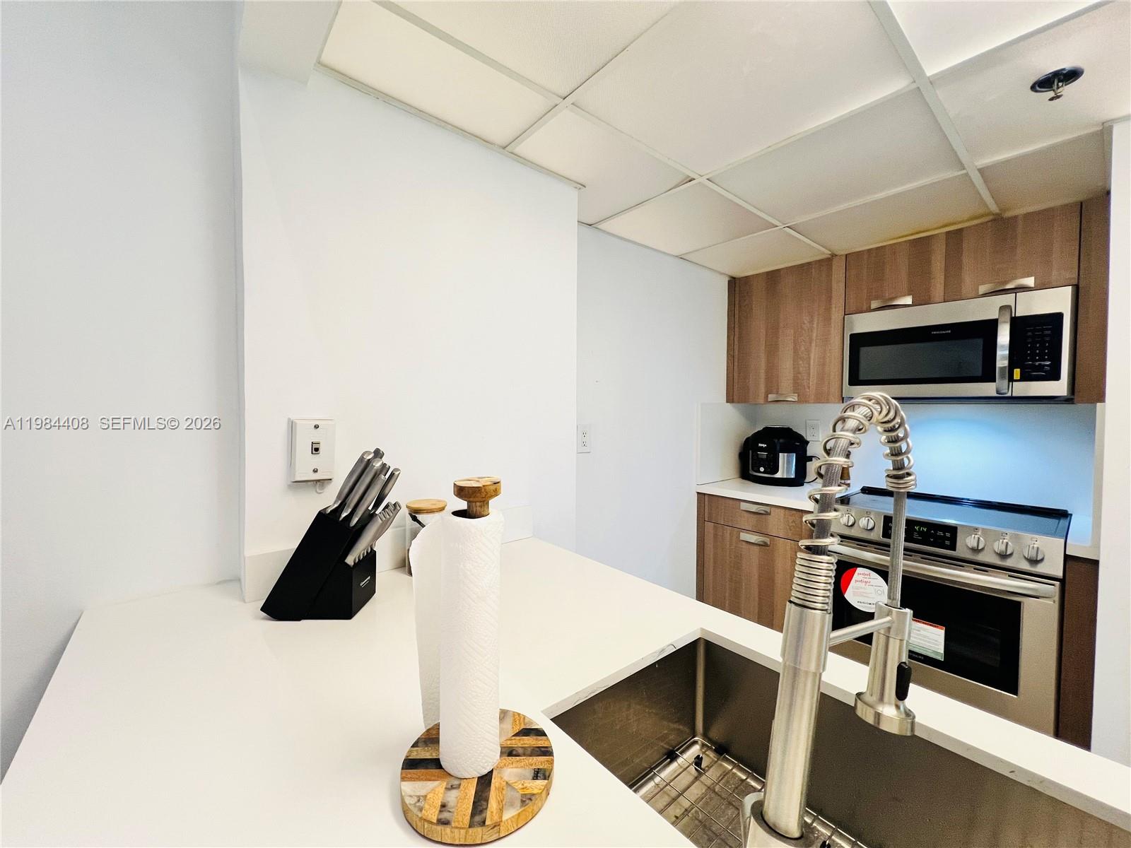 540 Brickell Key Drive, Unit 202 Miami, FL 33131 - Photo 15 of 31 a kitchen with microwave a stove and cabinets