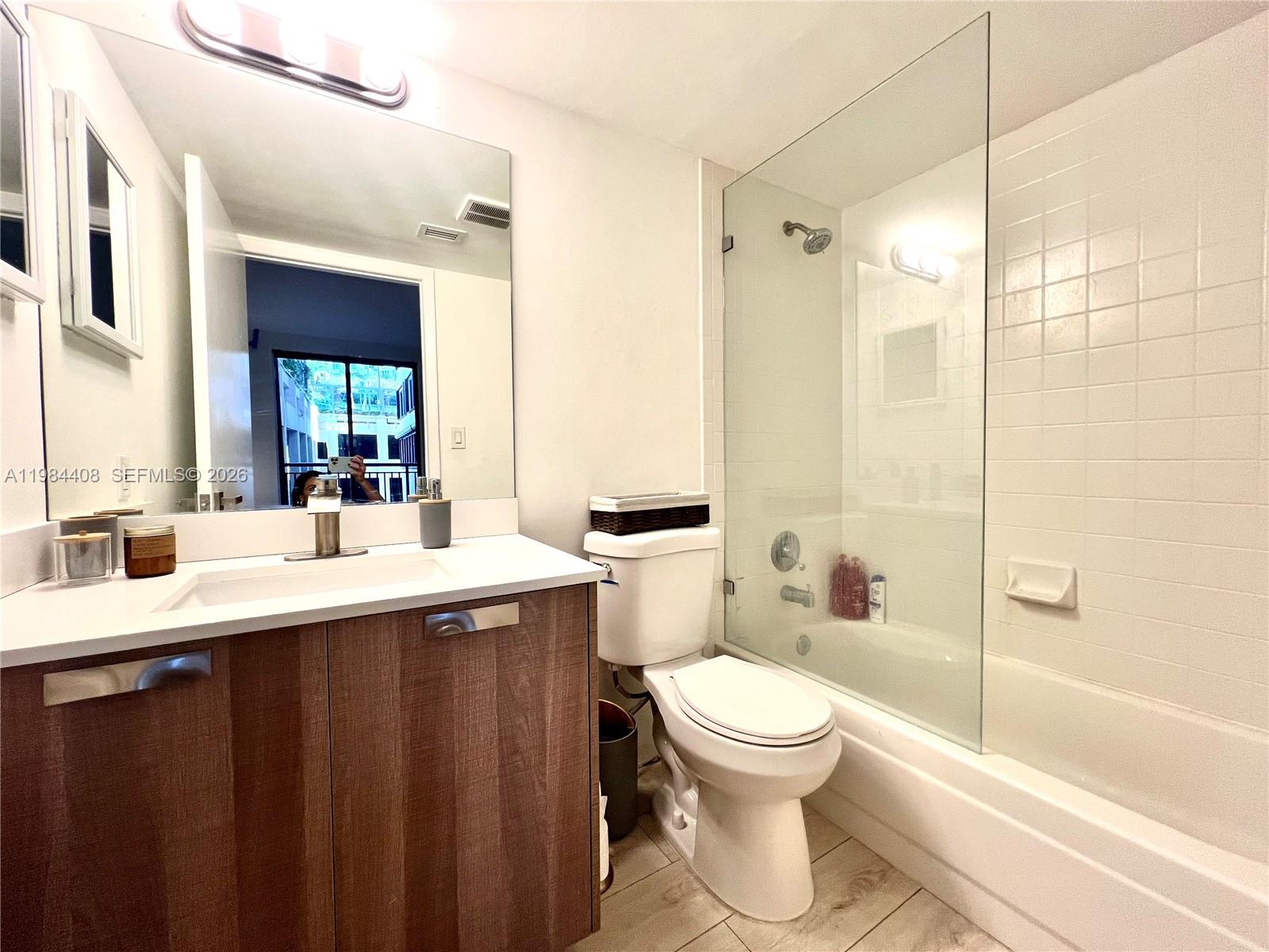 540 Brickell Key Drive, Unit 202 Miami, FL 33131 - Photo 22 of 31 a bathroom with a sink toilet a mirror and shower