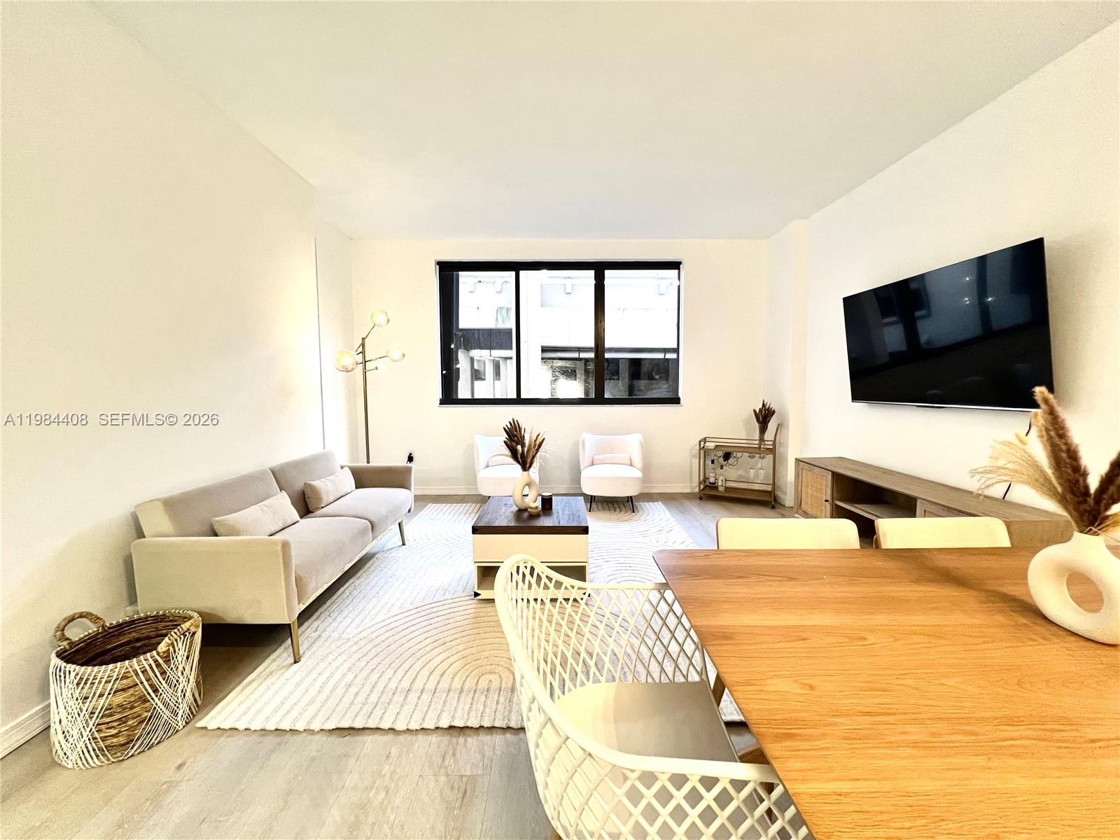 540 Brickell Key Drive, Unit 202 Miami, FL 33131 - Photo 6 of 31 a living room with furniture and a flat screen tv