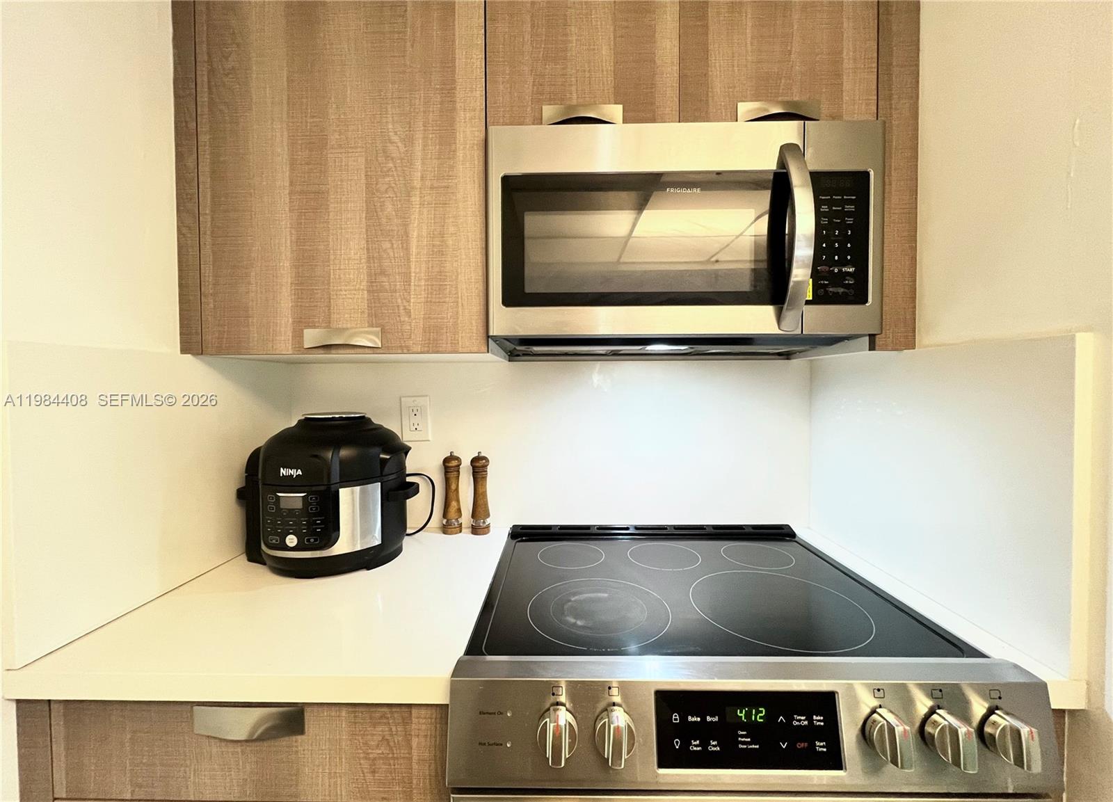 540 Brickell Key Drive, Unit 202 Miami, FL 33131 - Photo 10 of 31 a kitchen with a stove and a microwave