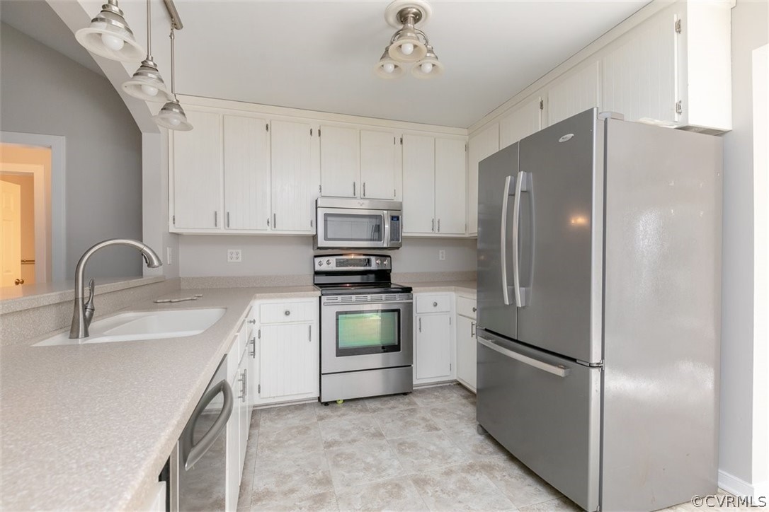 Kitchen w/ SS appliances and solid surface counter