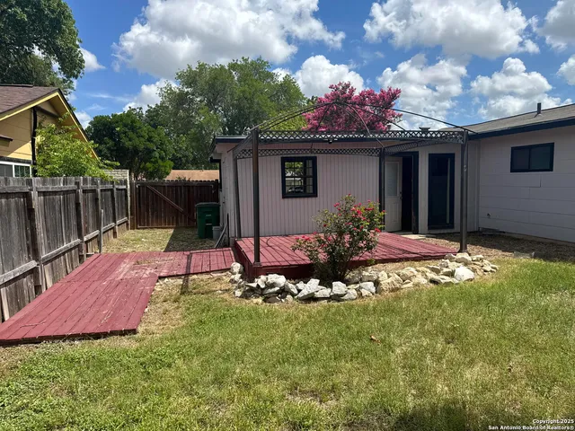 a view of a house with backyard and sitting area