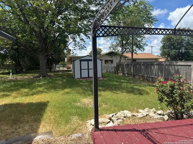 a view of a house with a yard balcony and a tree