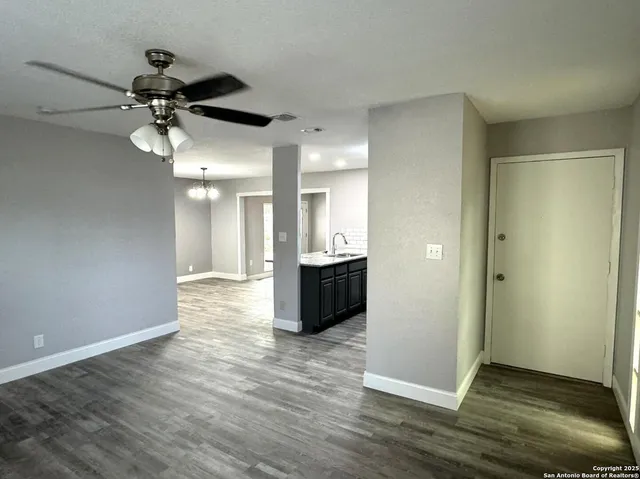 a view of a big room with wooden floor and windows