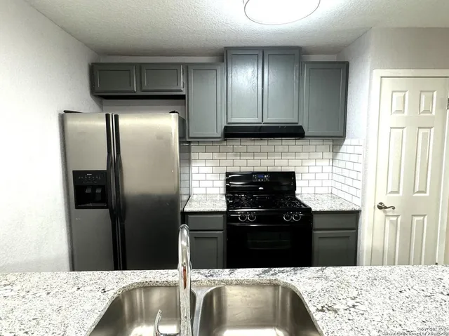 a kitchen with a refrigerator and a sink