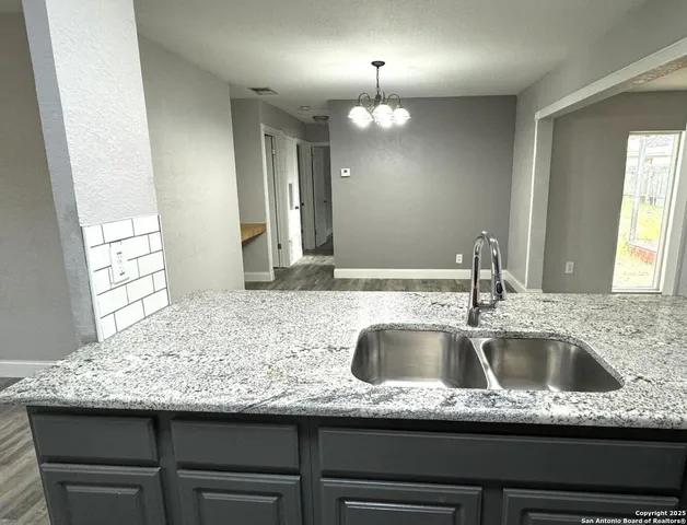 a kitchen with a sink and a wooden floor