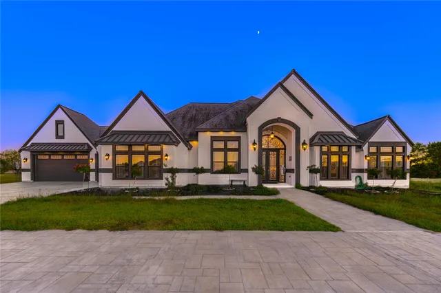 a front view of a house with a yard and potted plants