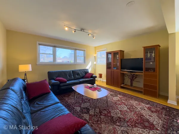 a living room with furniture and a wooden floor