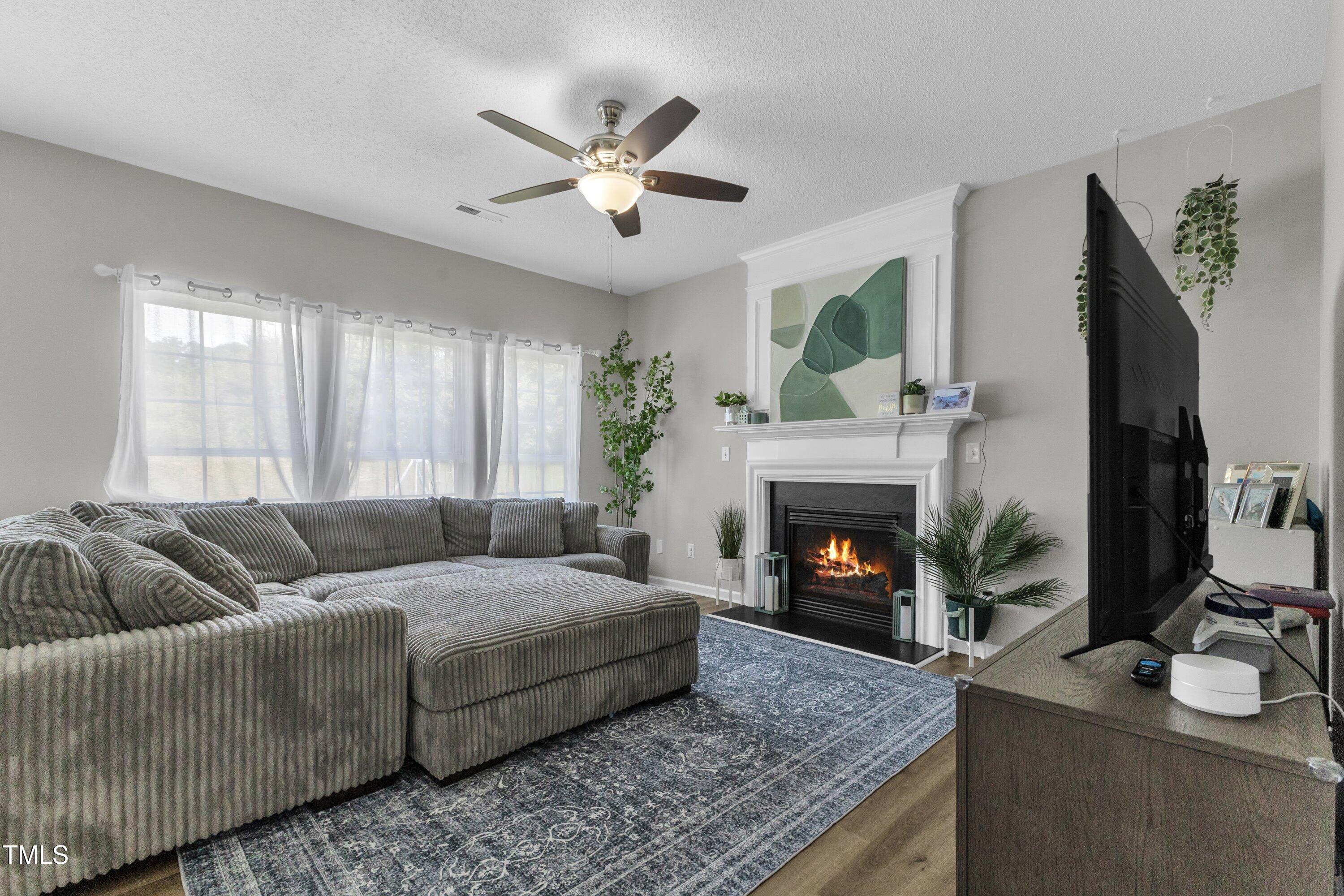 4105 Crowfield Drive Raleigh, NC 27610 - Photo 10 of 38 a living room with furniture and a fireplace
