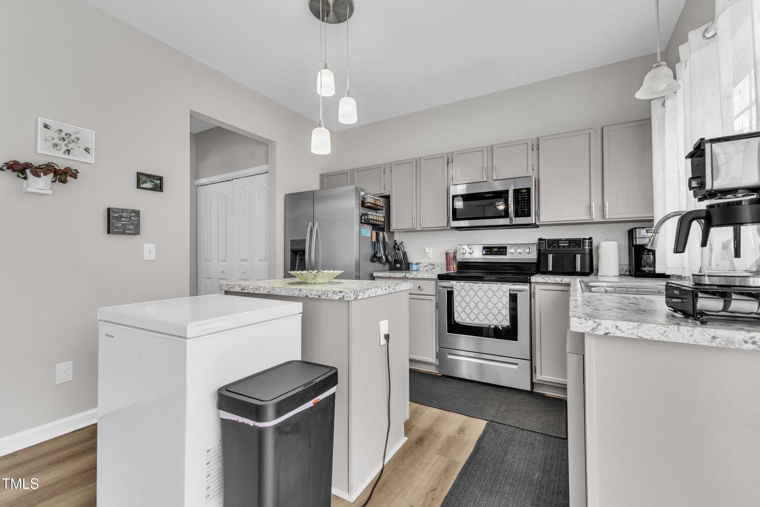 4105 Crowfield Drive Raleigh, NC 27610 - Photo 14 of 38 a kitchen with white cabinets and stainless steel appliances
