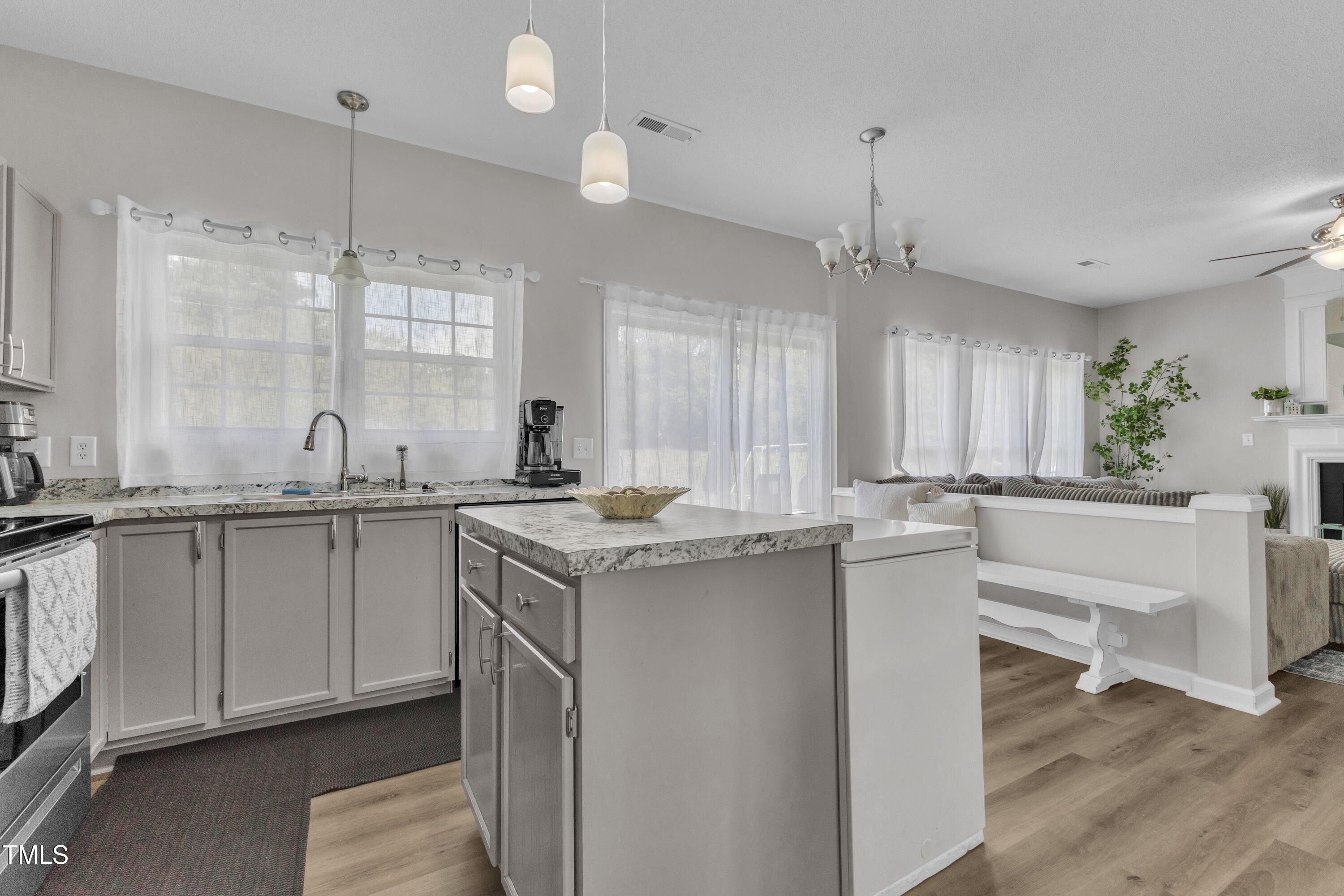 4105 Crowfield Drive Raleigh, NC 27610 - Photo 15 of 38 a kitchen with granite countertop a sink cabinets and wooden floor