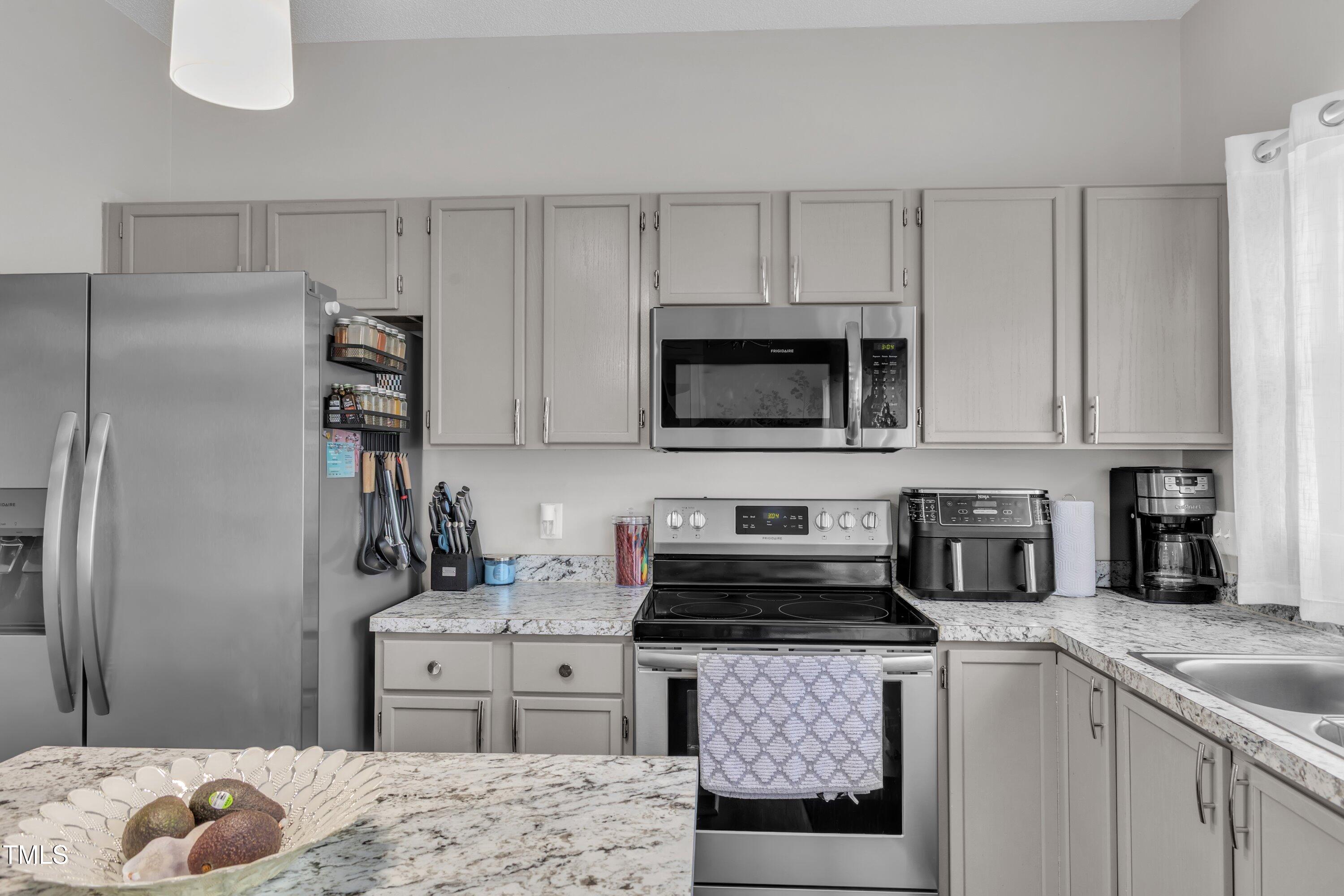 4105 Crowfield Drive Raleigh, NC 27610 - Photo 17 of 38 a kitchen with kitchen island granite countertop a sink stove and refrigerator