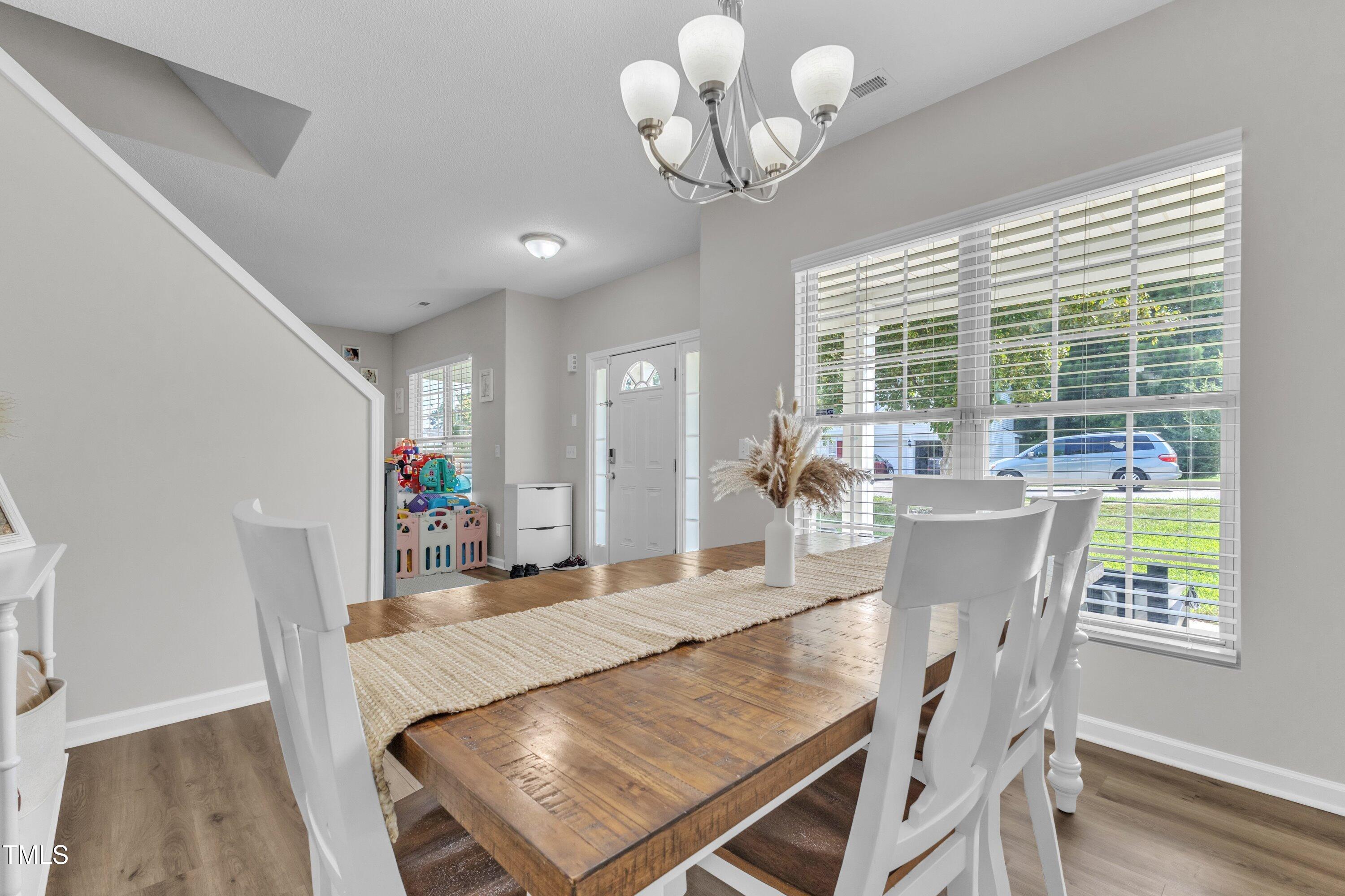 4105 Crowfield Drive Raleigh, NC 27610 - Photo 20 of 38 a view of a dining room with furniture wooden floor and chandelier