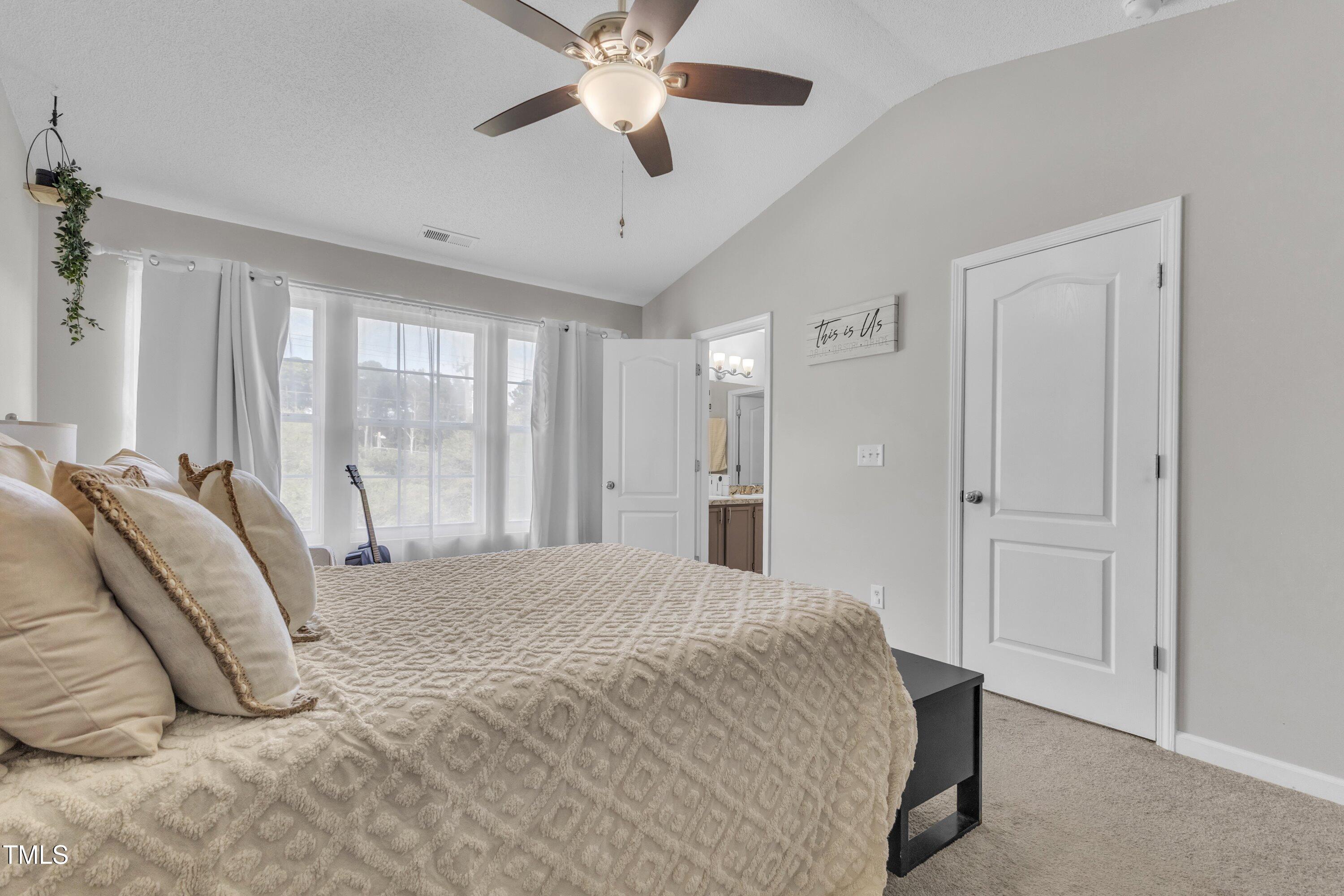 4105 Crowfield Drive Raleigh, NC 27610 - Photo 23 of 38 a bedroom with a bed and a chandelier