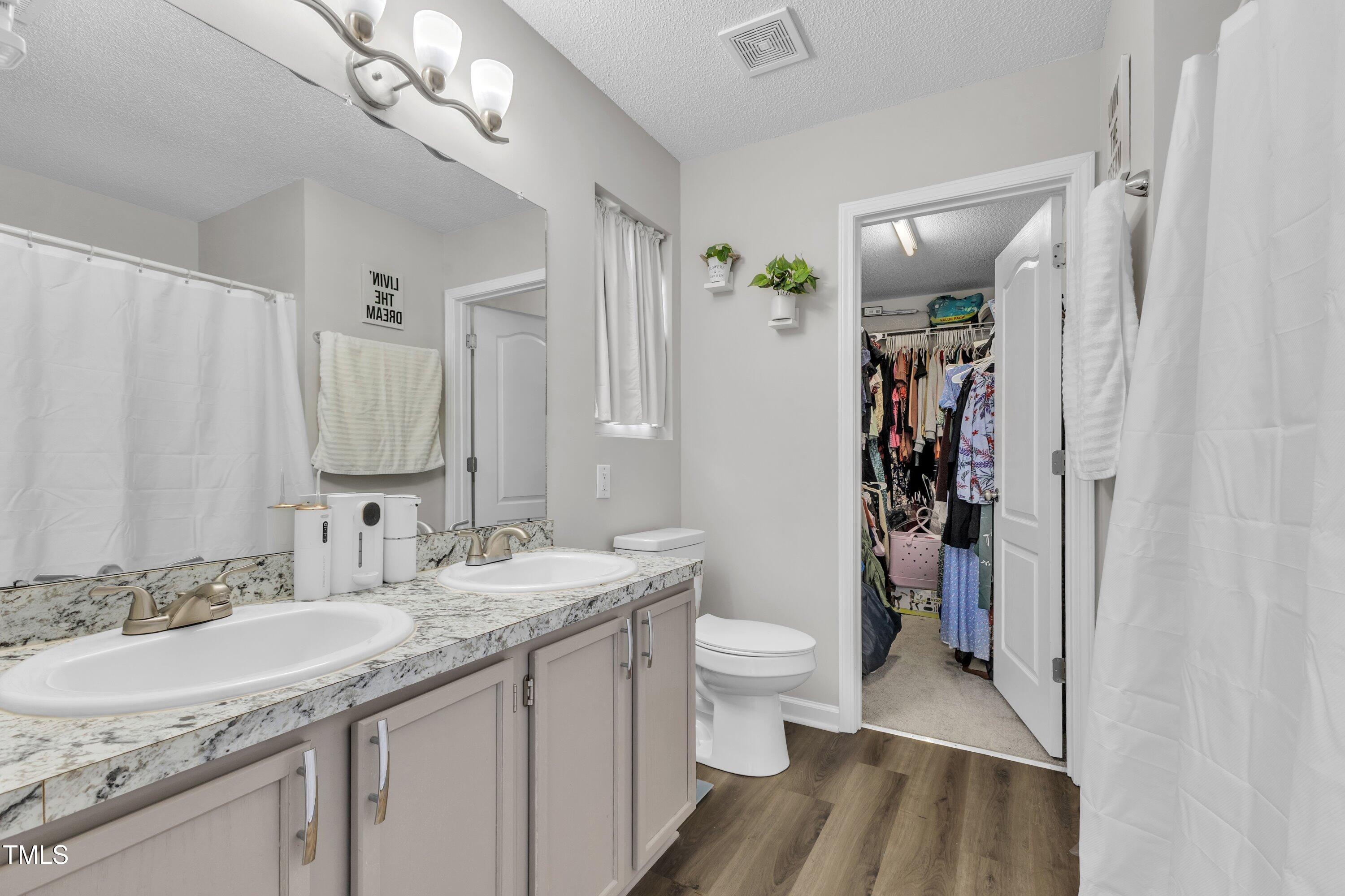 4105 Crowfield Drive Raleigh, NC 27610 - Photo 25 of 38 a bathroom with a granite countertop sink a toilet and a mirror
