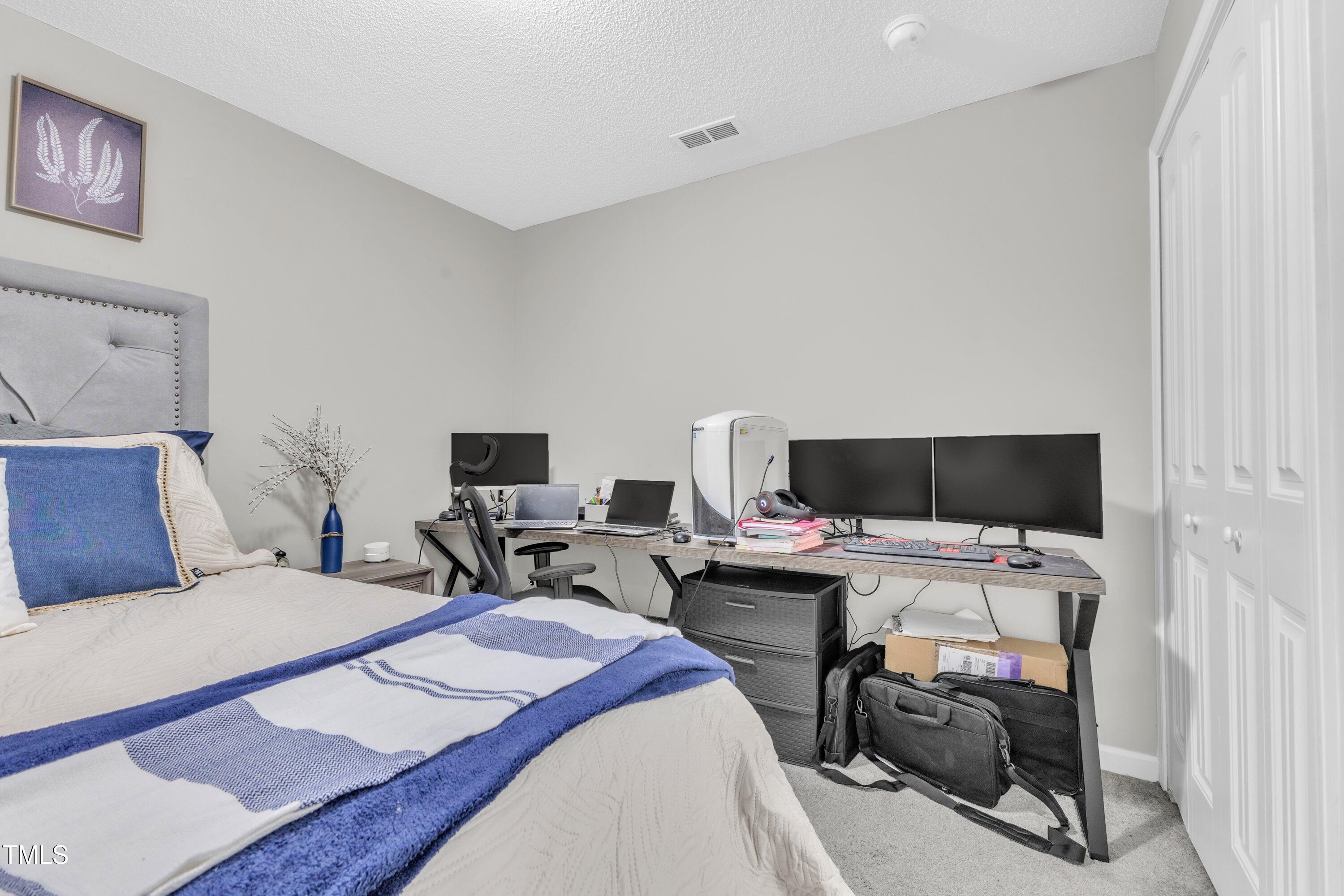 4105 Crowfield Drive Raleigh, NC 27610 - Photo 32 of 38 a bedroom with a bed and a flat screen tv