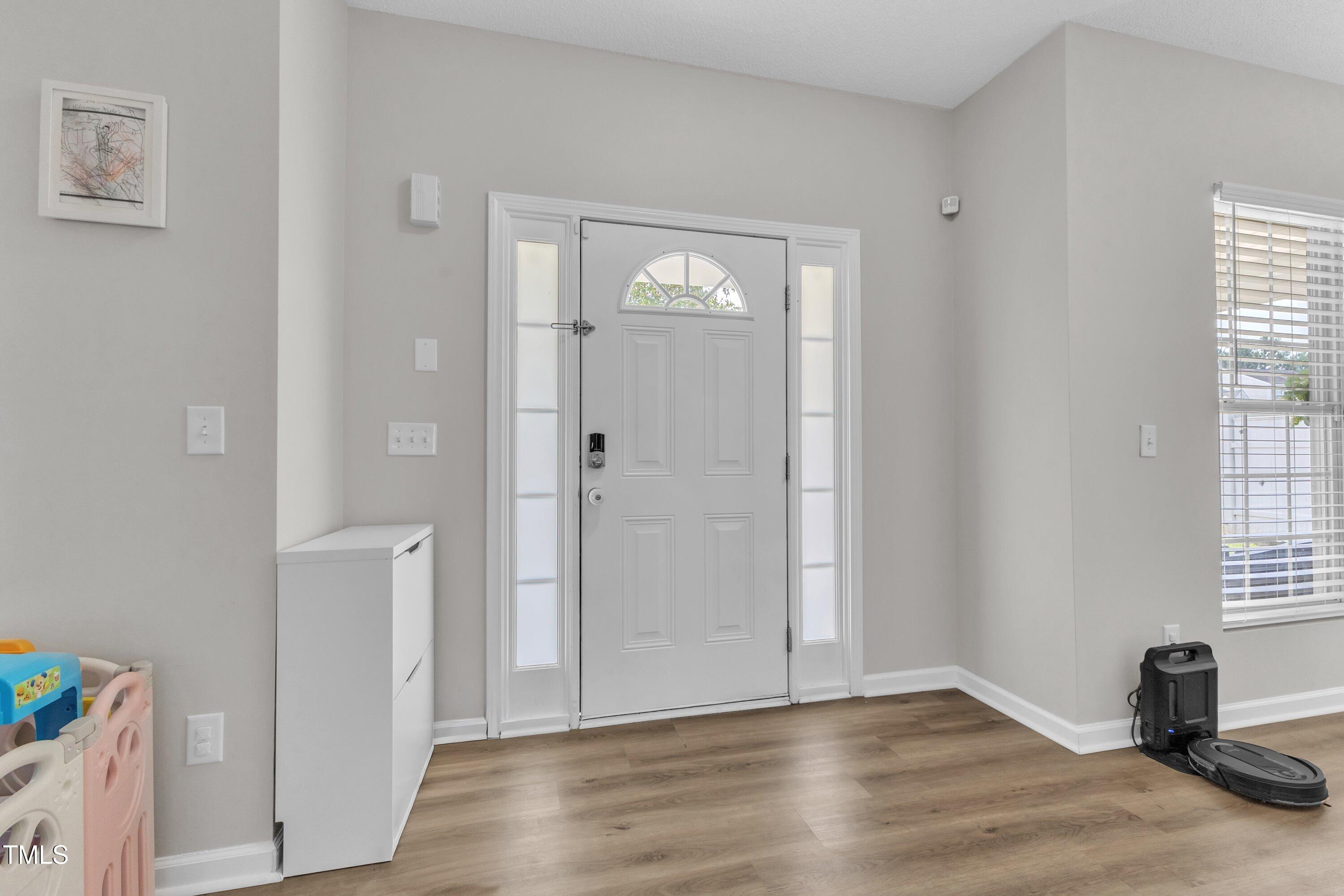 4105 Crowfield Drive Raleigh, NC 27610 - Photo 8 of 38 a view of an empty room with wooden floor and a window