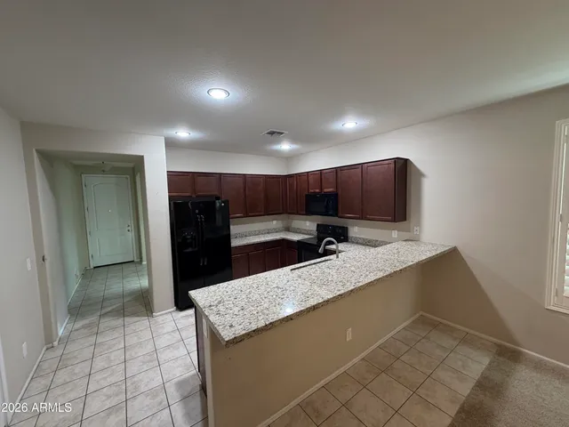 a kitchen with stainless steel appliances granite countertop a refrigerator and a sink