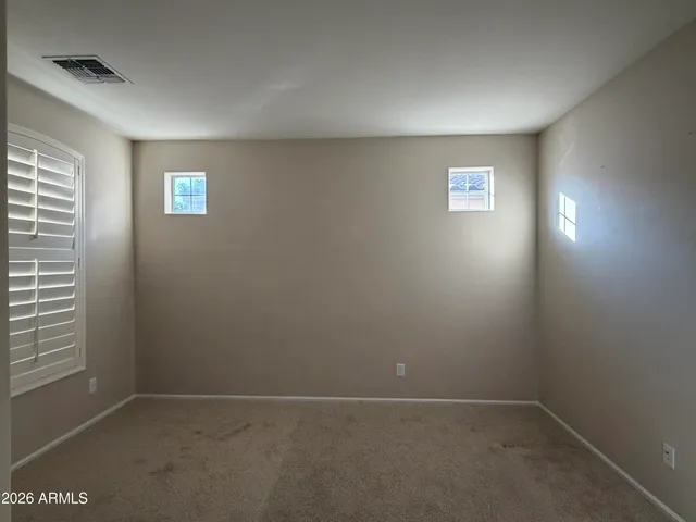 a view of a livingroom with a chandelier fan and windows