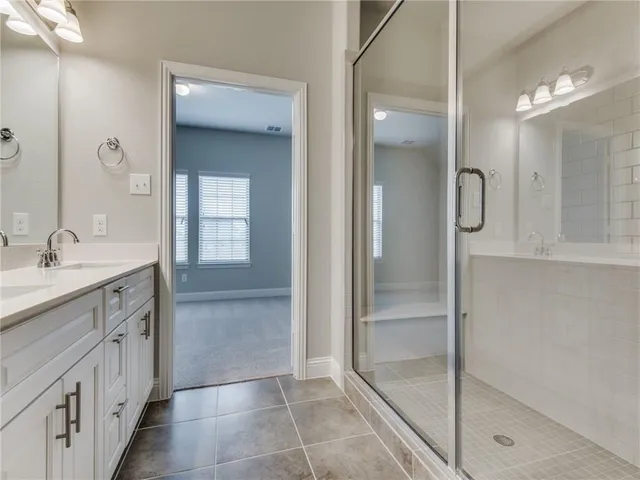 a bathroom with a shower sink and mirror