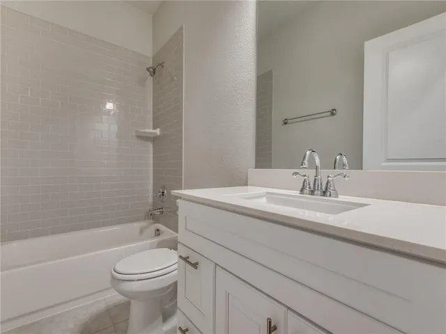 a bathroom with a granite countertop toilet a sink and a bathtub