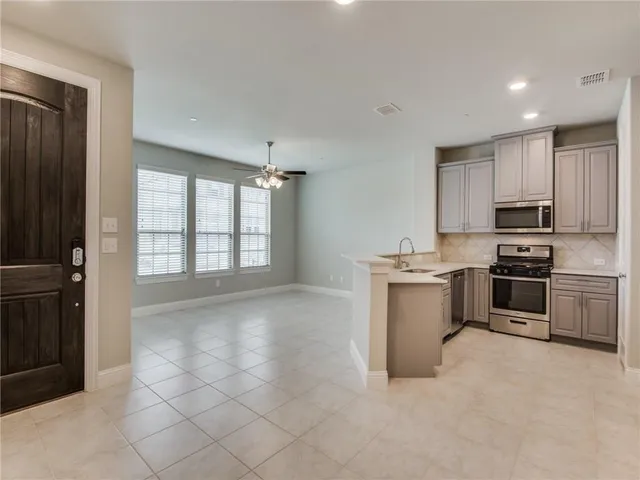 a kitchen with white cabinets and appliances