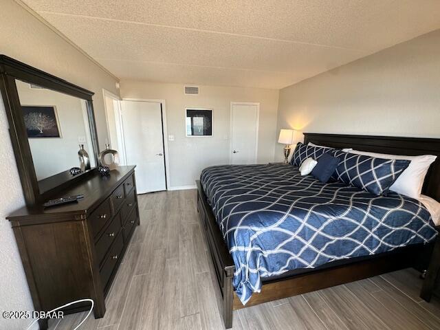 2700 Ocean Shore Boulevard, Unit 301 Ormond Beach, FL 32176 - Photo 24 of 42 a bedroom with a bed and wooden floor
