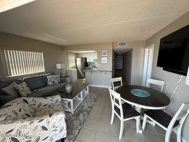 2700 Ocean Shore Boulevard, Unit 301 Ormond Beach, FL 32176 - Photo 3 of 42 a living room with furniture a flat screen tv and kitchen view