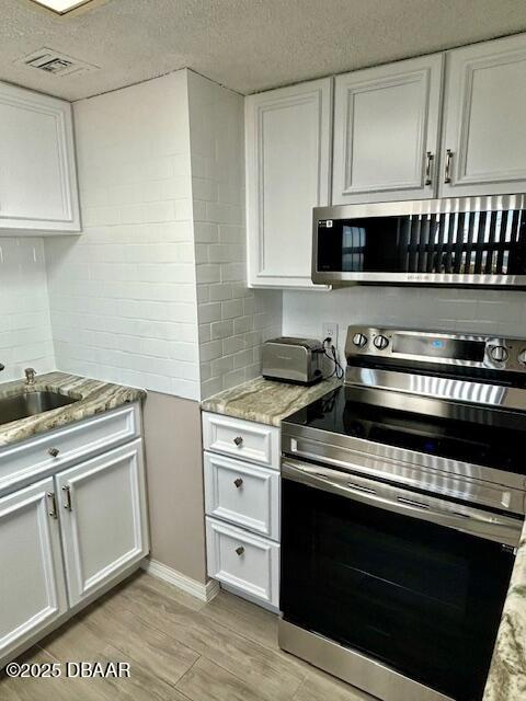 2700 Ocean Shore Boulevard, Unit 301 Ormond Beach, FL 32176 - Photo 4 of 42 a kitchen with cabinets and appliances