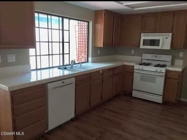 a kitchen with stainless steel appliances granite countertop a stove a sink and a microwave