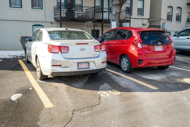 a front view of a house with cars parked