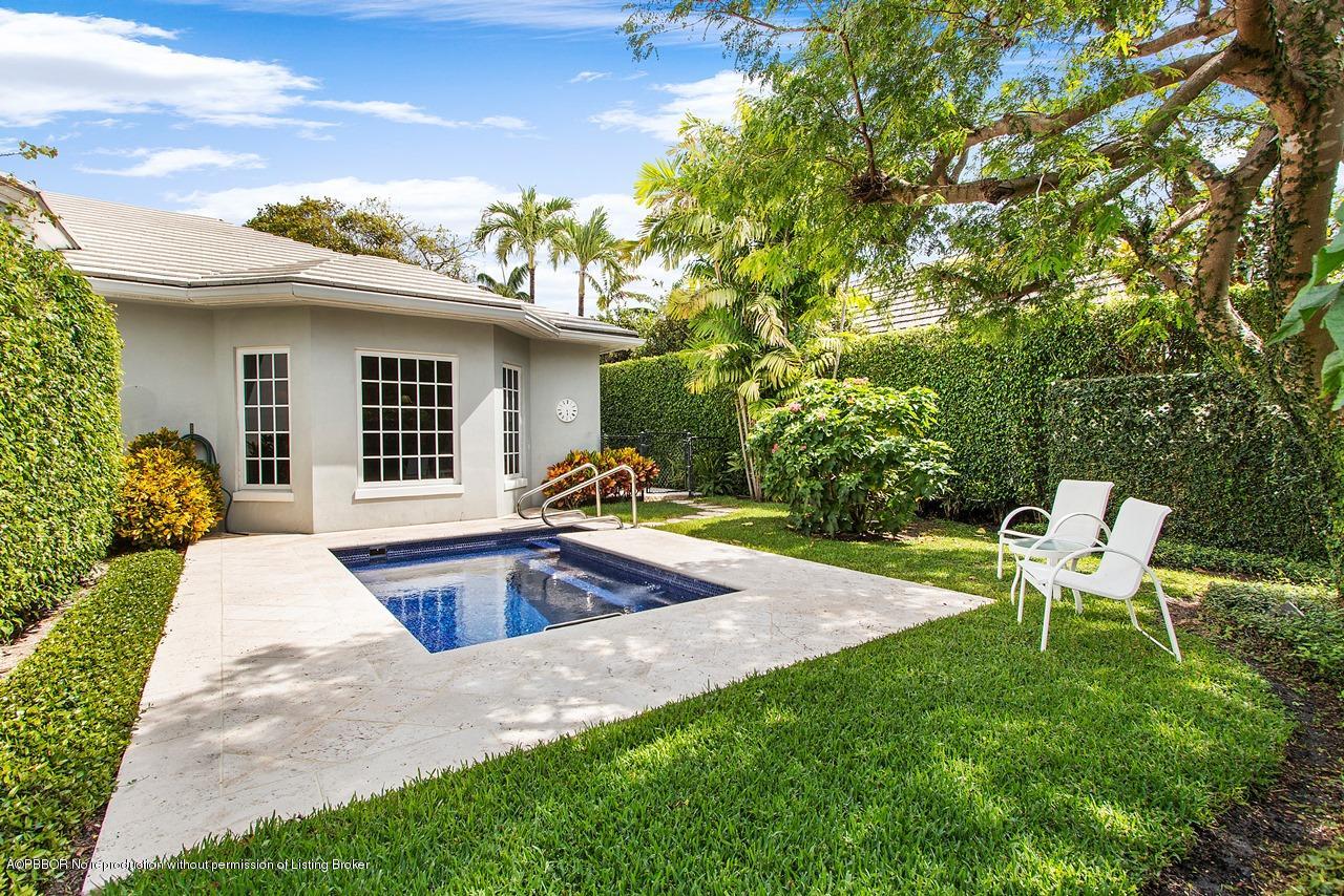 a view of a backyard with table and chairs with wooden fence and plants