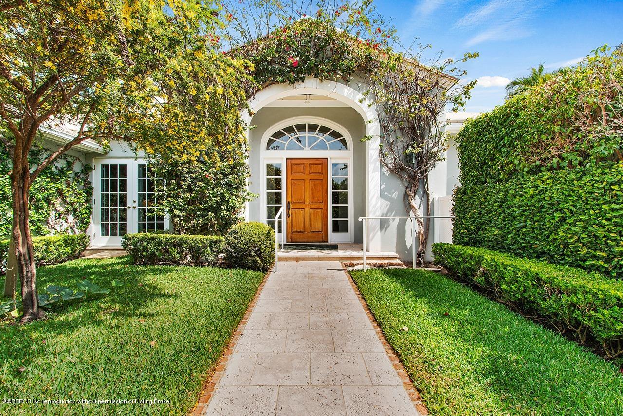 255 Ridgeview Drive Palm Beach, FL 33480 - Photo 2 of 20 a view of a house with brick walls and a small yard with plants