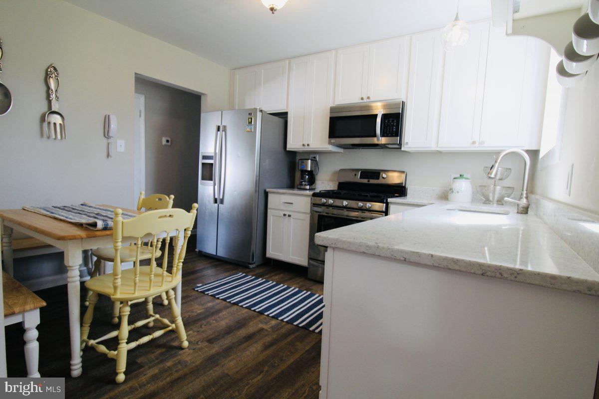 388 Nimitz Road Dover, DE 19901 - Photo 10 of 25 a kitchen with stainless steel appliances a dining table chairs microwave and sink